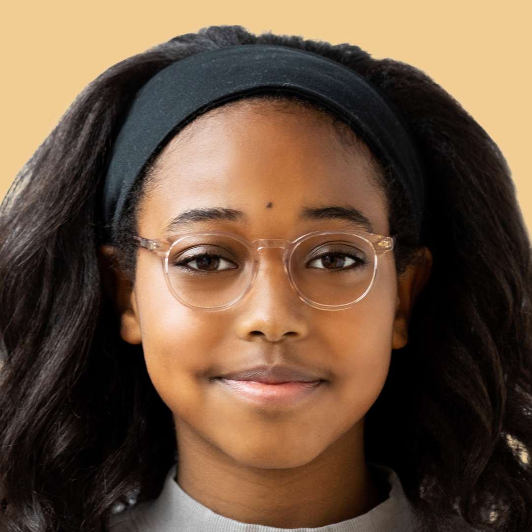 Girl wearing pink circle glasses and a gray shirt 