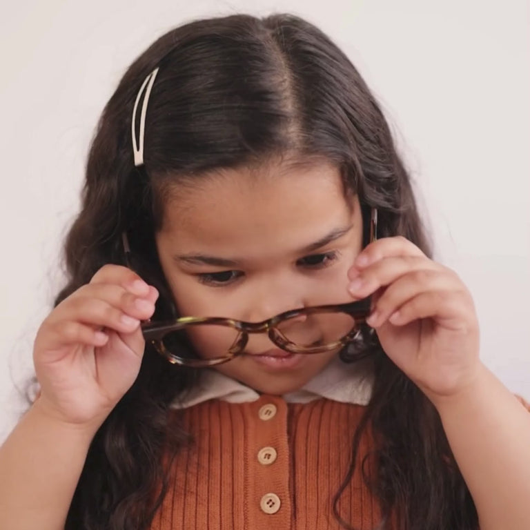Girl wearing Small (43-15-125) / Striped Maple round glasses [variants=22362866909269, 22362866417749] [color=Striped Maple] [size=Small (43-15-125)][child face] 
