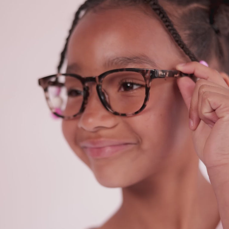 Girl wearing Medium (46-17-130) / Crystal Tortoise square glasses [variants=40262213468245, 40262212878421, 40634108739669] [color=Crystal Tortoise] [size=Medium (46-17-130), Small (44-17-125)][child face]