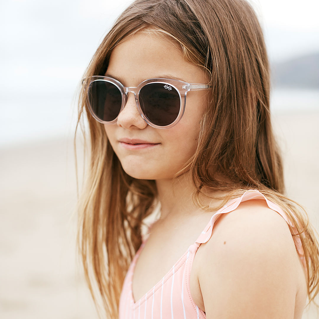 Girl wearing clear round sunglasses and a pink shirt 